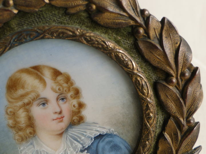 アンティーク・フレーム＞ブラス・フレーム＞ローレル・リースのブラス・フレーム。緻密に描かれているのは、ブルーの瞳とカールの金髪が美しい少年。・・・・・「ナポレオン少年時代の肖像」とのこと。調べてみると、ナポレオン・ボナパルトの長男、ナポレオン２世、少年時代の『ナポレオン・フランソワ・シャルル・ジョゼフ・ボナパルト』（ Napoléon II : Napoléon François Charles Joseph Bonaparte）ではないかと思われるのですが・・・・。いずれにしても極めて繊細で、大変に美しいフレームです。＞アイボリーにハンドペイント　フランス製　1850年頃　Φ＝７㎝　／　絵の部分　Φ＝４㎝