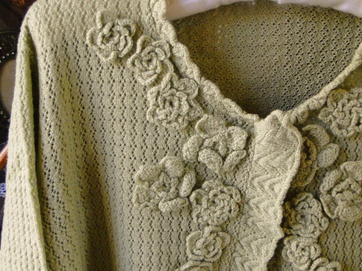 ＜バドローズ　マーリア　水野　陽子　 2014年　秋冬コレクション＞カーディガン＞襟ぐりから前開き、裾周りにかけてお花のモティーフをふんだんにあしらったボレロ風カーディガンです。＞ウール 100％　　オリーブ